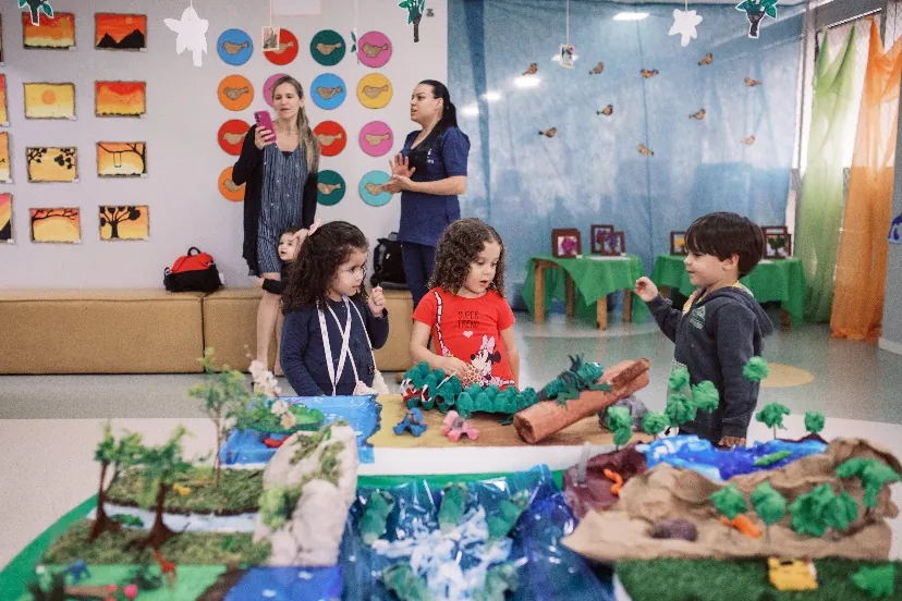 Crianças participando de atividade pedagógica com maquete
